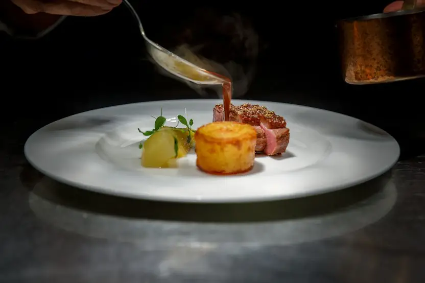 Chef plating a steak dish